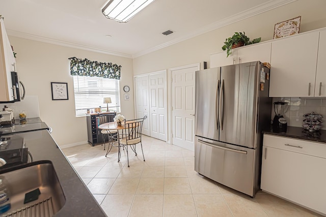 590 NW Cortina Ln, Port Saint Lucie, FL 34986 - kitchen featuring appliances with stainless steel finishes, backsplash, crown molding, light tile patterned floors, and dark countertops