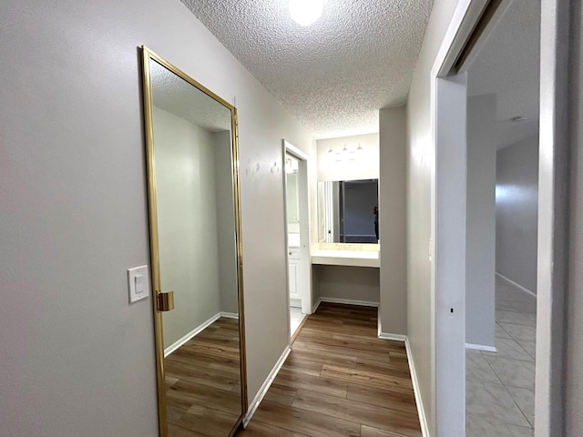 5725 Fernley Dr E Unit 71, West Palm Beach, FL 33415 - corridor featuring a textured ceiling, wood finished floors, and baseboards