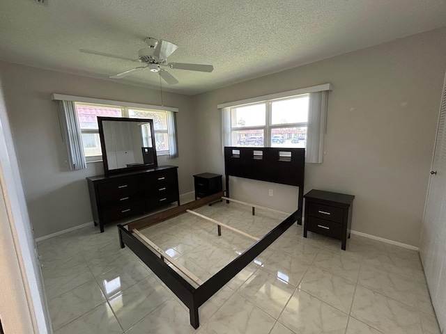 5725 Fernley Dr E Unit 71, West Palm Beach, FL 33415 - bedroom with light marble finish flooring, baseboards, a textured ceiling, and ceiling fan