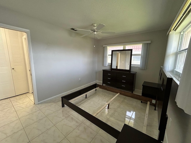 5725 Fernley Dr E Unit 71, West Palm Beach, FL 33415 - bedroom featuring light marble finish flooring, baseboards, a textured ceiling, and ceiling fan