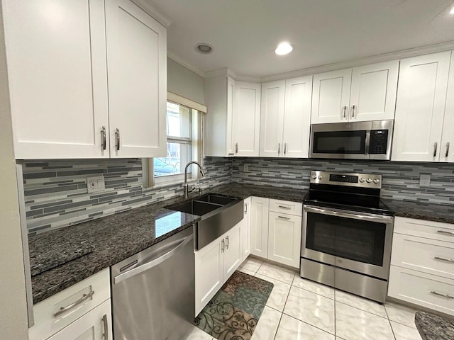 5725 Fernley Dr E Unit 71, West Palm Beach, FL 33415 - kitchen featuring stainless steel appliances, a sink, white cabinets, crown molding, and backsplash