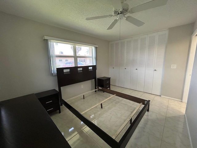 5725 Fernley Dr E Unit 71, West Palm Beach, FL 33415 - bedroom featuring light marble finish flooring, a textured ceiling, baseboards, and a ceiling fan
