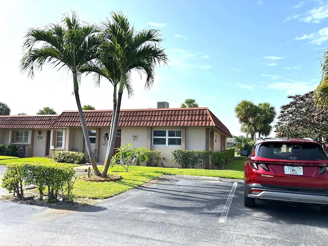 5725 Fernley Dr E Unit 71, West Palm Beach, FL 33415 - view of front of house with a tiled roof, stucco siding, uncovered parking, and a front yard
