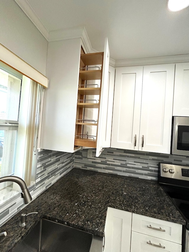 5725 Fernley Dr E Unit 71, West Palm Beach, FL 33415 - kitchen featuring appliances with stainless steel finishes, a sink, tasteful backsplash, white cabinetry, and dark stone countertops