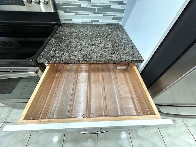 5725 Fernley Dr E Unit 71, West Palm Beach, FL 33415 - kitchen view of dark stone countertops, decorative backsplash, and range