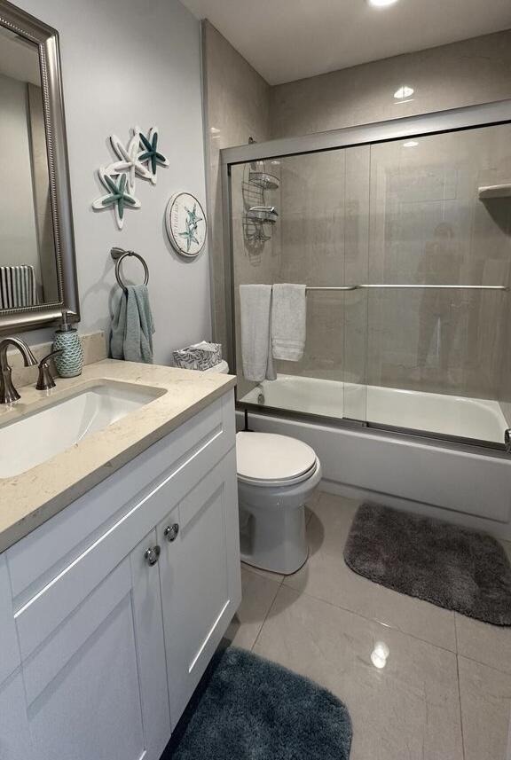 420 Normandy I 420, Delray Beach, FL 33484 - bathroom with vanity, tile patterned flooring, toilet, and combined bath / shower with glass door