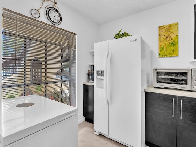 2027 SW 15th St Unit 177, Deerfield Beach, FL 33442 - kitchen with white refrigerator with ice dispenser, light tile patterned floors, light countertops, and a textured ceiling