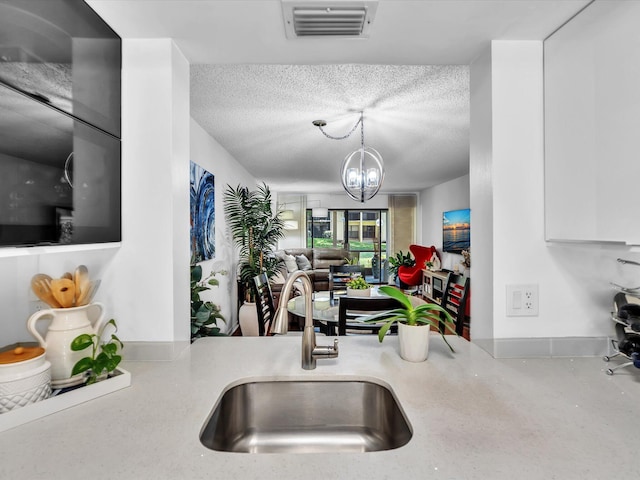 2027 SW 15th St Unit 177, Deerfield Beach, FL 33442 - kitchen with a sink, a chandelier, a textured ceiling, open floor plan, and light countertops