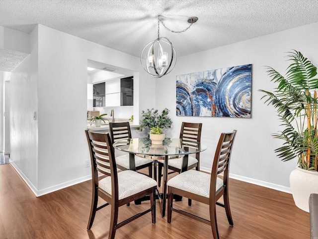 2027 SW 15th St Unit 177, Deerfield Beach, FL 33442 - dining space with wood finished floors, a chandelier, a textured ceiling, and baseboards
