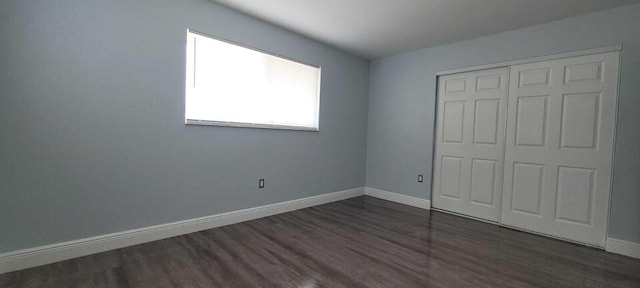 9258 N Military Trl, Palm Beach Gardens, FL 33410 - unfurnished bedroom with dark wood-style floors, baseboards, and a closet