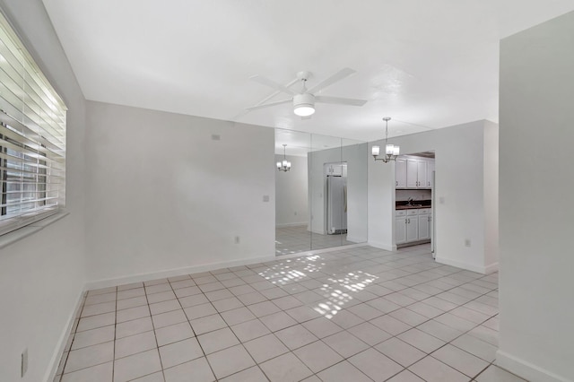 650 SW 2nd Ave Unit 150, Boca Raton, FL 33432 - unfurnished room featuring a chandelier, a ceiling fan, light tile patterned floors, and baseboards