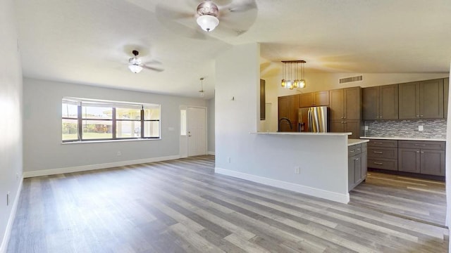 2569 SE Grand Dr, Port Saint Lucie, FL 34952 - kitchen featuring stainless steel refrigerator with ice dispenser, lofted ceiling, ceiling fan, light countertops, and tasteful backsplash
