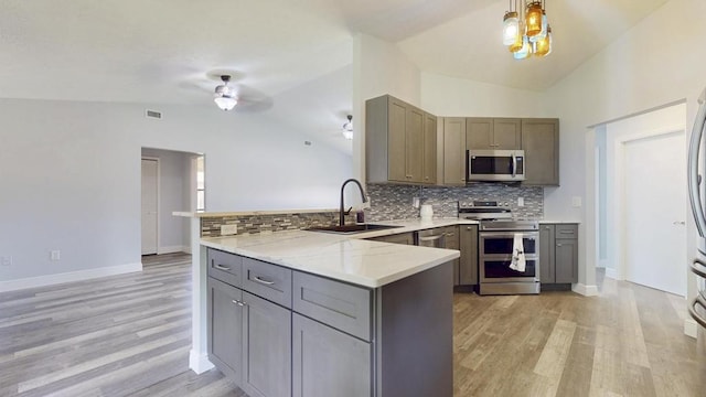 2569 SE Grand Dr, Port Saint Lucie, FL 34952 - kitchen with appliances with stainless steel finishes, a sink, lofted ceiling, a peninsula, and gray cabinetry