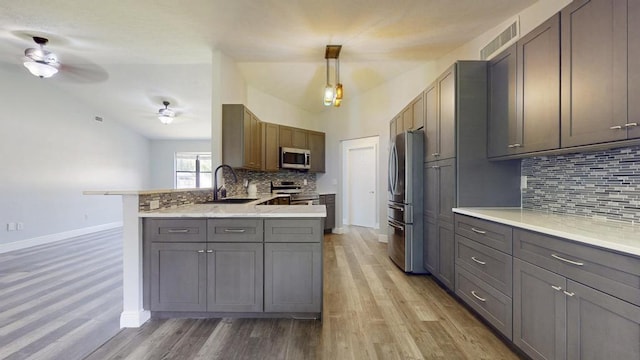 2569 SE Grand Dr, Port Saint Lucie, FL 34952 - kitchen featuring stainless steel appliances, a sink, baseboards, ceiling fan, and a peninsula