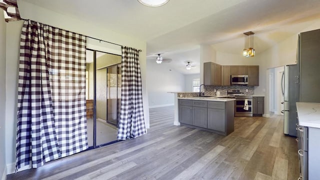 2569 SE Grand Dr, Port Saint Lucie, FL 34952 - kitchen featuring stainless steel appliances, wood finished floors, a ceiling fan, tasteful backsplash, and a sink