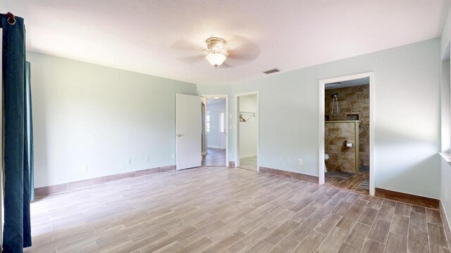 2569 SE Grand Dr, Port Saint Lucie, FL 34952 - unfurnished bedroom with light wood-type flooring, a walk in closet, baseboards, and ceiling fan