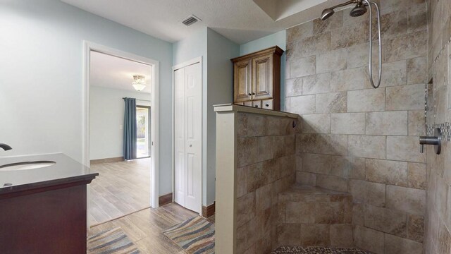 2569 SE Grand Dr, Port Saint Lucie, FL 34952 - full bath with vanity, a tile shower, wood finished floors, and baseboards