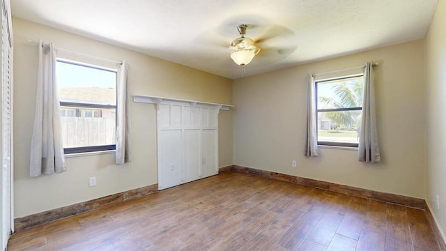 2569 SE Grand Dr, Port Saint Lucie, FL 34952 - unfurnished bedroom featuring multiple windows, wood finished floors, and baseboards