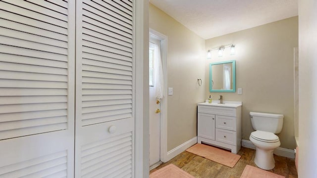 2569 SE Grand Dr, Port Saint Lucie, FL 34952 - bathroom with vanity, baseboards, wood finished floors, toilet, and a closet