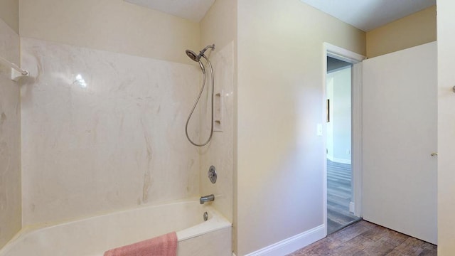 2569 SE Grand Dr, Port Saint Lucie, FL 34952 - bathroom with wood finished floors, tub / shower combination, and baseboards