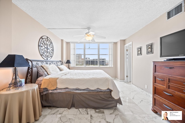 137 Golden Isles Dr Unit 804, Hallandale Beach, FL 33009 - bedroom with light marble finish flooring, ceiling fan, baseboards, and a textured ceiling