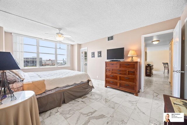 137 Golden Isles Dr Unit 804, Hallandale Beach, FL 33009 - bedroom featuring light marble finish flooring, a ceiling fan, and a textured ceiling