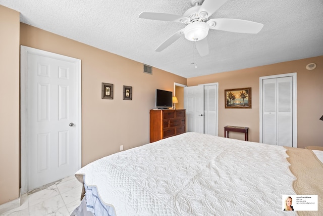 137 Golden Isles Dr Unit 804, Hallandale Beach, FL 33009 - bedroom featuring marble look tile flooring, a textured ceiling, multiple closets, and ceiling fan