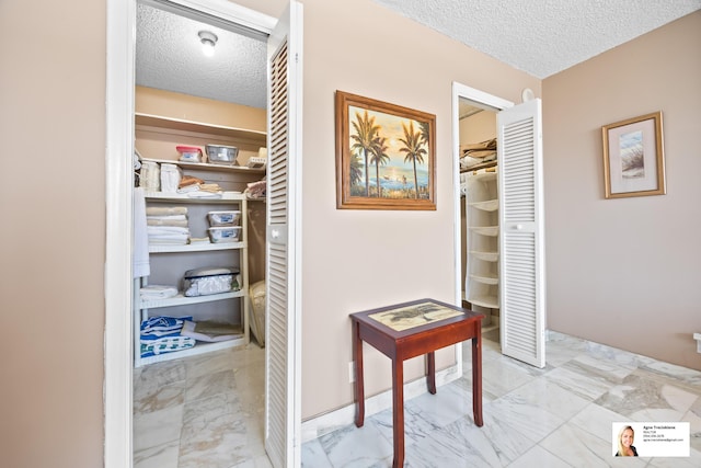 137 Golden Isles Dr Unit 804, Hallandale Beach, FL 33009 - hall featuring a textured ceiling and marble finish flooring