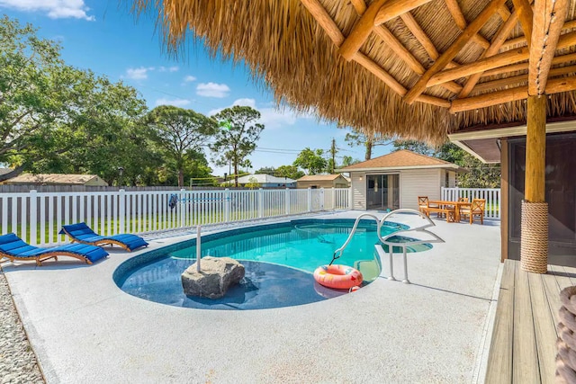 2550 SE Calais St, Port Saint Lucie, FL 34952 - view of pool with an outdoor structure, a fenced backyard, and a patio