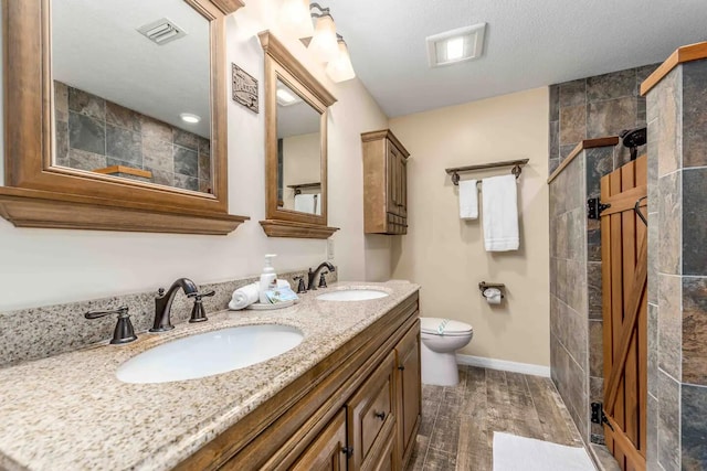 2550 SE Calais St, Port Saint Lucie, FL 34952 - full bathroom with double vanity, a walk in shower, wood finished floors, and toilet