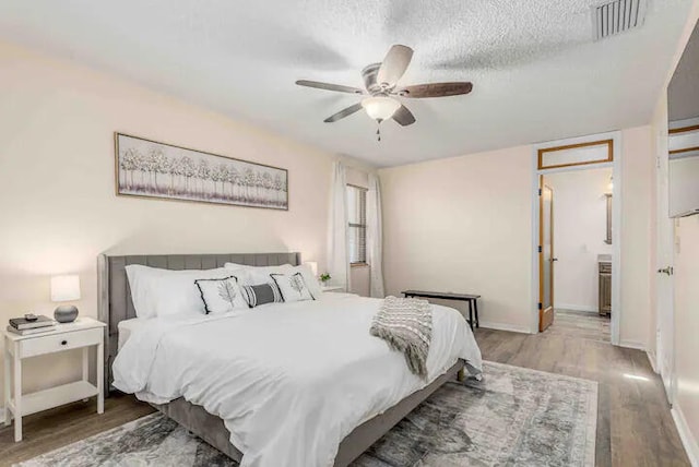 2550 SE Calais St, Port Saint Lucie, FL 34952 - bedroom featuring wood finished floors, baseboards, a ceiling fan, and a textured ceiling