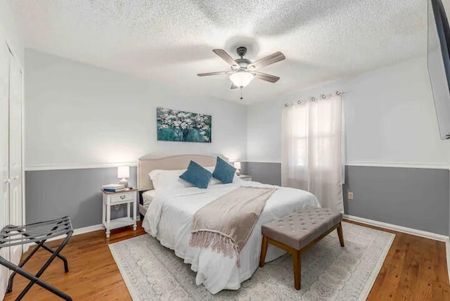 2550 SE Calais St, Port Saint Lucie, FL 34952 - bedroom featuring a textured ceiling, wood finished floors, baseboards, and ceiling fan