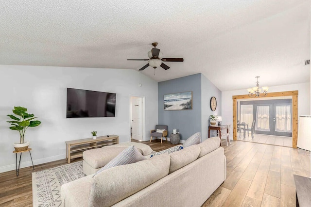 2550 SE Calais St, Port Saint Lucie, FL 34952 - living area with a chandelier, light wood finished floors, ceiling fan, vaulted ceiling, and a textured ceiling