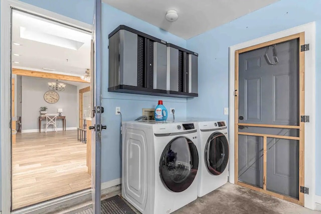 2550 SE Calais St, Port Saint Lucie, FL 34952 - laundry room featuring cabinet space, washer and dryer, a chandelier, and baseboards