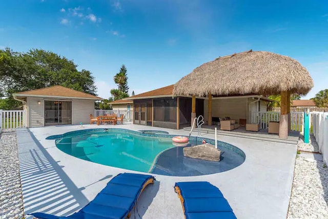 2550 SE Calais St, Port Saint Lucie, FL 34952 - view of swimming pool featuring a sunroom, a patio, an outdoor living space, and a pool with connected hot tub