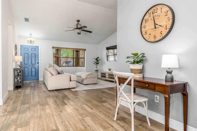 2550 SE Calais St, Port Saint Lucie, FL 34952 - living room featuring ceiling fan, wood finished floors, vaulted ceiling, baseboards, and a chandelier