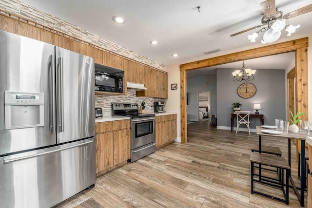 2550 SE Calais St, Port Saint Lucie, FL 34952 - kitchen featuring appliances with stainless steel finishes, under cabinet range hood, tasteful backsplash, recessed lighting, and light wood finished floors