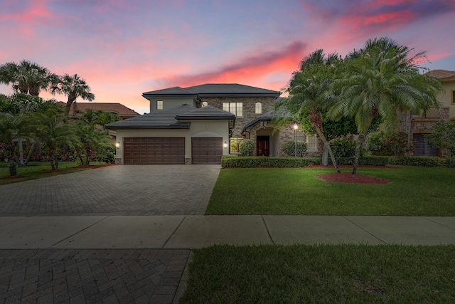 10523 Vignon Ct, Wellington, FL 33449 - view of front of home featuring stone siding, a garage, decorative driveway, stucco siding, and a yard