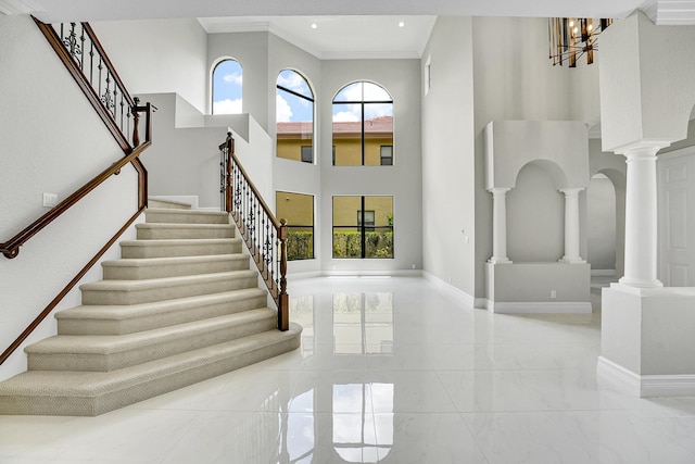 10523 Vignon Ct, Wellington, FL 33449 - entryway featuring plenty of natural light, stairs, marble tiled floors, decorative columns, and a towering ceiling