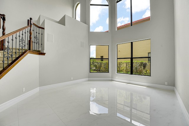 10523 Vignon Ct, Wellington, FL 33449 - unfurnished living room with marble tiled floors, baseboards, a high ceiling, and stairs