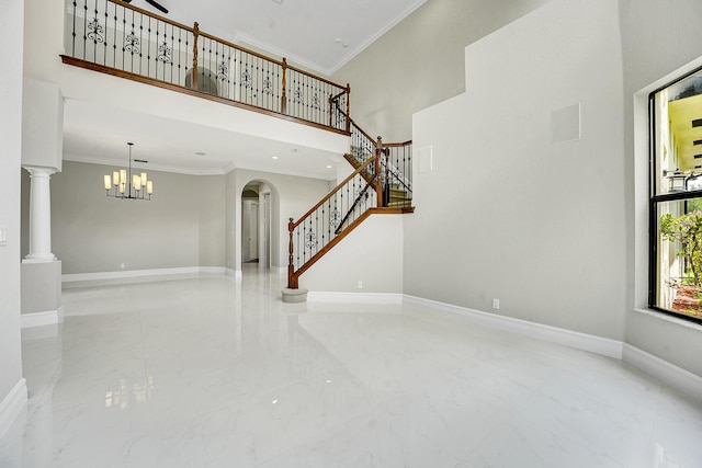 10523 Vignon Ct, Wellington, FL 33449 - unfurnished living room featuring arched walkways, marble tiled flooring, a towering ceiling, crown molding, and stairs