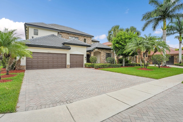 10523 Vignon Ct, Wellington, FL 33449 - view of front of property featuring stucco siding, decorative driveway, a garage, a front lawn, and a tiled roof