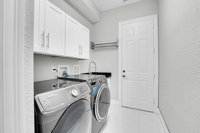 10523 Vignon Ct, Wellington, FL 33449 - laundry room with cabinet space, washing machine and dryer, baseboards, and a textured wall