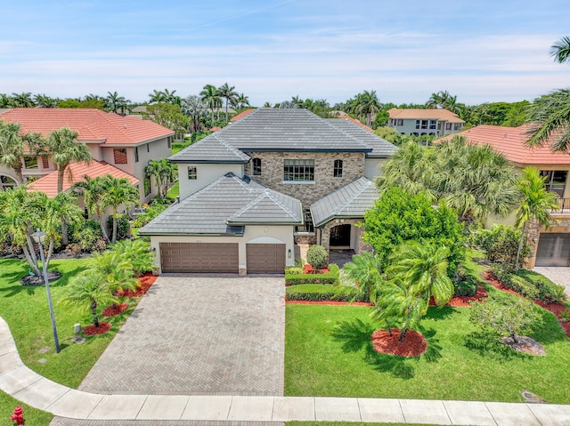 10523 Vignon Ct, Wellington, FL 33449 - view of front facade with stone siding, stucco siding, driveway, an attached garage, and a front yard