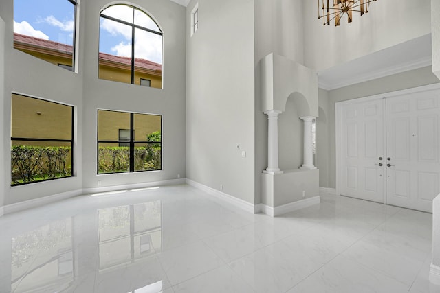 10523 Vignon Ct, Wellington, FL 33449 - foyer entrance with a towering ceiling, ornate columns, plenty of natural light, arched walkways, and baseboards