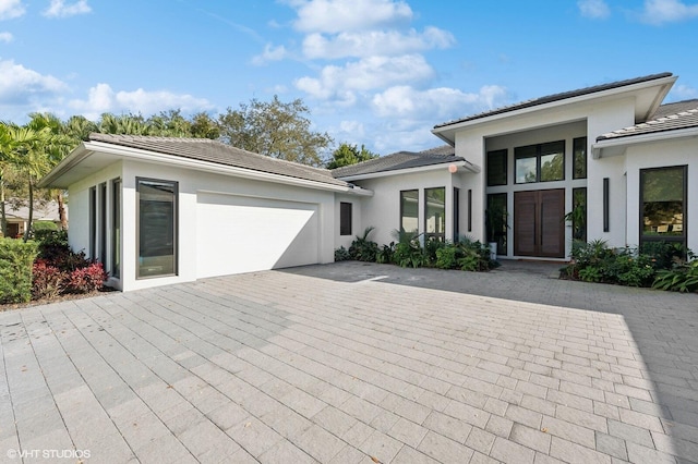 8533 N Native Dancer Rd, Palm Beach Gardens, FL 33418 - view of front facade with an attached garage, driveway, stucco siding, and a tiled roof
