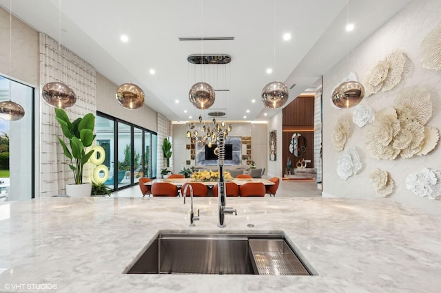 8533 N Native Dancer Rd, Palm Beach Gardens, FL 33418 - kitchen featuring a sink, open floor plan, light stone countertops, recessed lighting, and hanging light fixtures