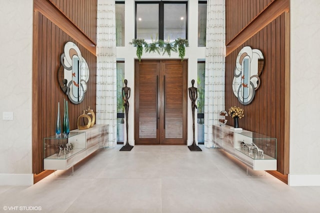 8533 N Native Dancer Rd, Palm Beach Gardens, FL 33418 - entryway with wooden walls, a high ceiling, and baseboards