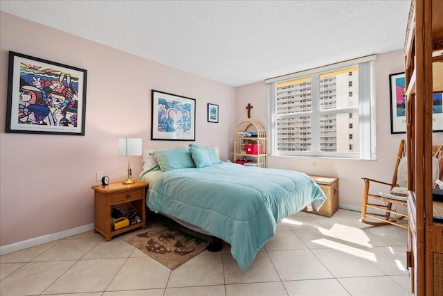 1009 N Ocean Blvd Unit 510, Pompano Beach, FL 33062 - bedroom with a textured ceiling, baseboards, and light tile patterned floors