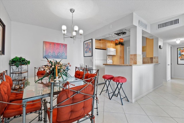 1009 N Ocean Blvd Unit 510, Pompano Beach, FL 33062 - dining space featuring a textured ceiling, a chandelier, light tile patterned floors, and baseboards